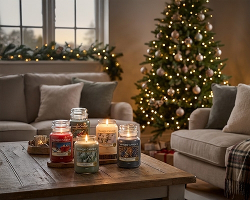 Salon décoré pour Noël avec des bougies Yankee Candle sur une table.